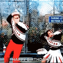 two spartan cheerleaders are dancing in front of a chain link fence