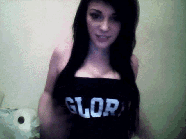 a woman wearing a black top with the word glory on it
