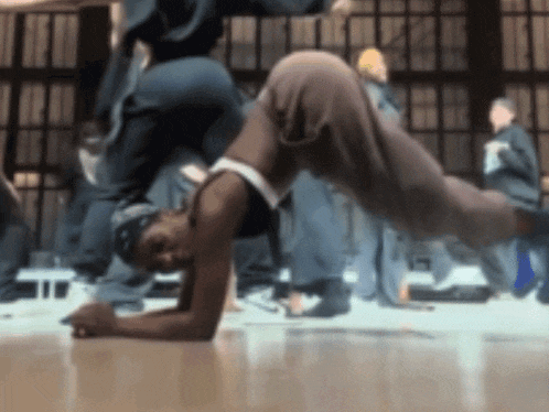 a man is doing a handstand on a dance floor