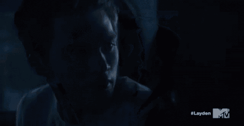 a close up of a person 's face in a dark room with a mtv logo in the corner .