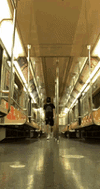 a subway car with a person walking down the aisle
