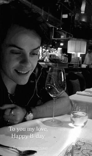 a man sits at a table with a glass of wine and a candle with the words to you my love happy b day