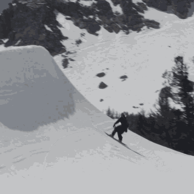 a person skiing down a snow covered slope with trees in the background