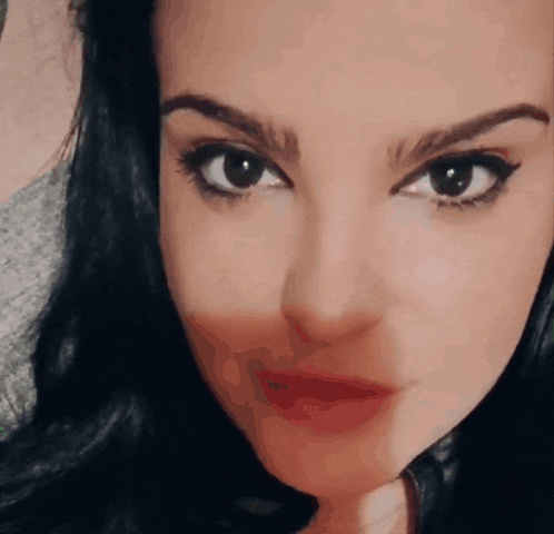 a close up of a woman 's face with a slight smile on her face