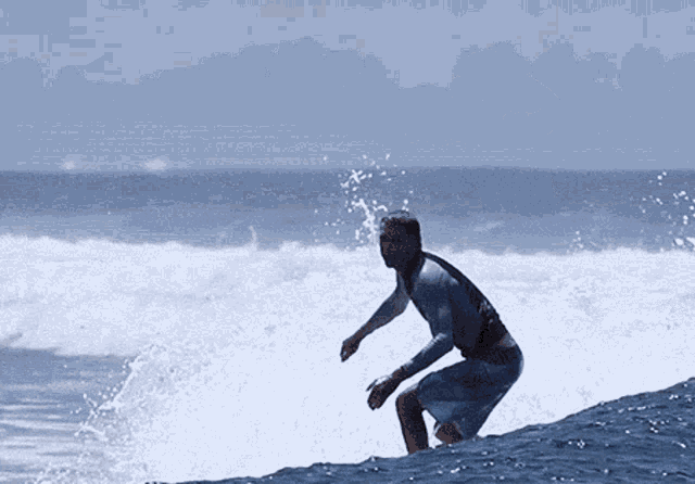 a man is riding a wave on a surfboard