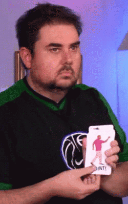 a man in a green and black shirt is holding a card that says " dont "