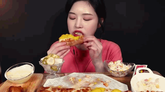 a woman is eating a slice of pizza with a lot of toppings on the table