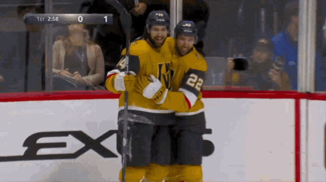a hockey player with the number 22 on his jersey hugs another player
