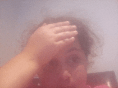a child covering her face with her hand