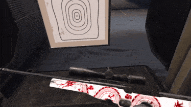 a sniper rifle with a red dragon on it is sitting on a table in front of a target