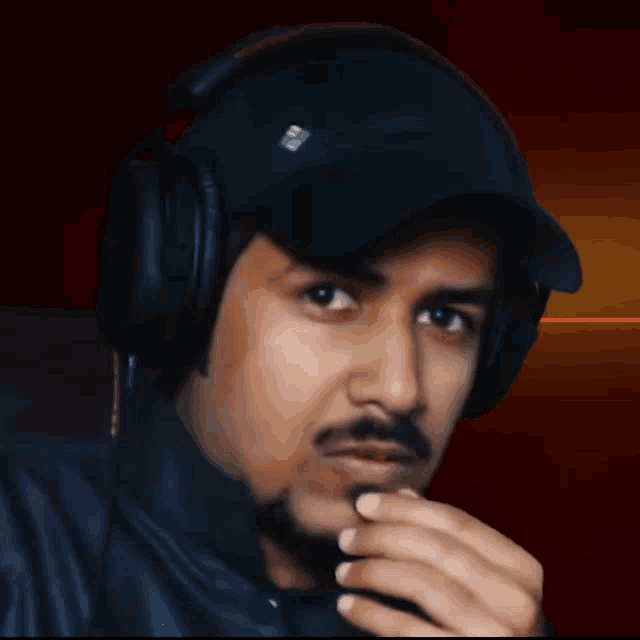 a man wearing headphones and a hat with a sticker that says ' a ' on it