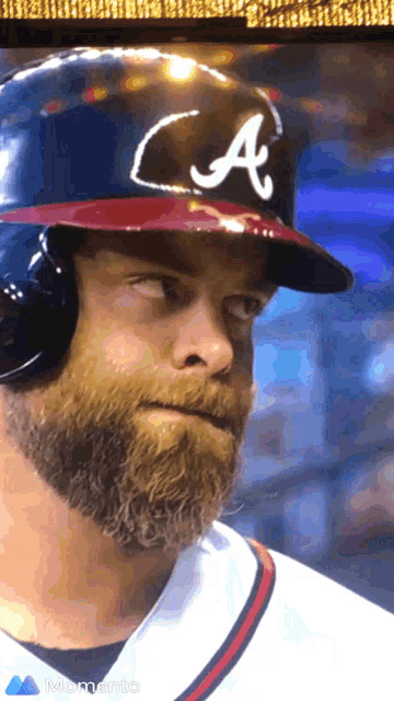 a man with a beard wears a baseball helmet with the letter a on it