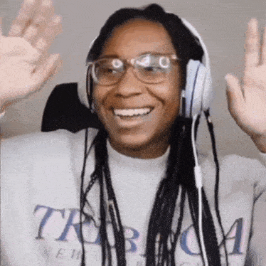a woman wearing headphones and glasses is smiling .