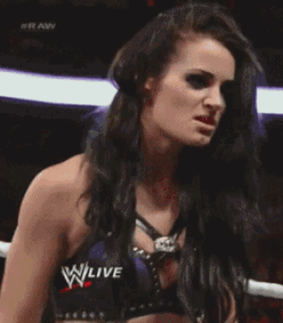 a woman in a wrestling ring with a sign that says w live on it