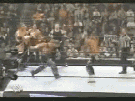 a blurred image of a wrestling match with a referee watching
