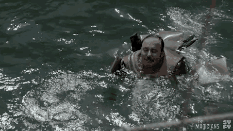 a man is swimming in the water with a life preserver on his back .