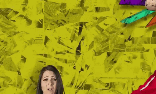 a woman is standing in front of a yellow wall with a bunch of papers on it .