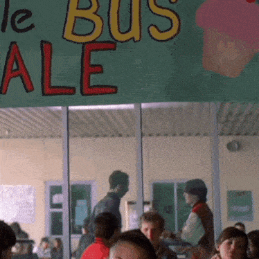 a group of people are gathered under a sign that says bus ale