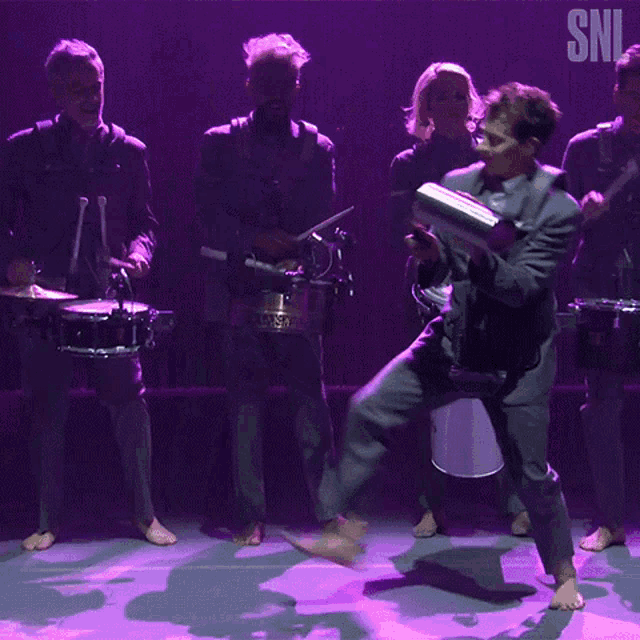a snl logo can be seen in the corner of a purple stage