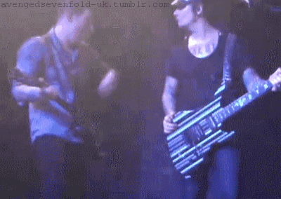 a man playing a guitar with the website avengedsevenfold-uk.tumblr.com visible in the corner