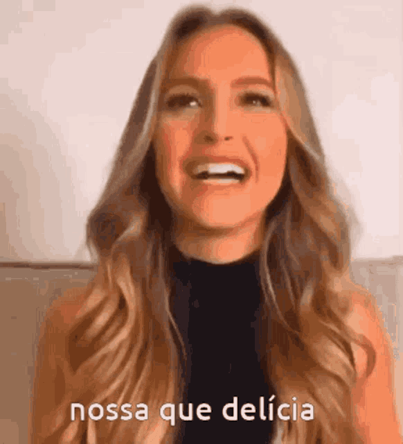 a woman with long blonde hair is laughing and says nossa que delicia .