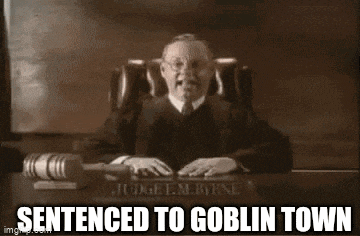 a judge is sitting at a desk with a gavel and the words sentenced to goblin town written on it .