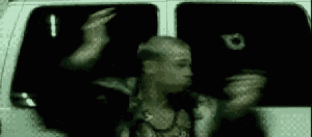 a man is standing in front of a white van with his arms outstretched .
