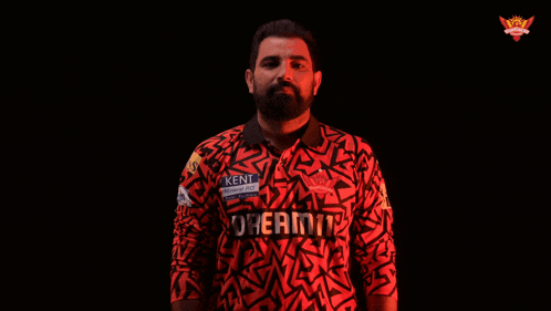 a man in a kent shirt is holding a ball