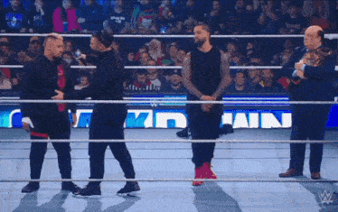 wrestlers in a wrestling ring with a sign that says win in the background