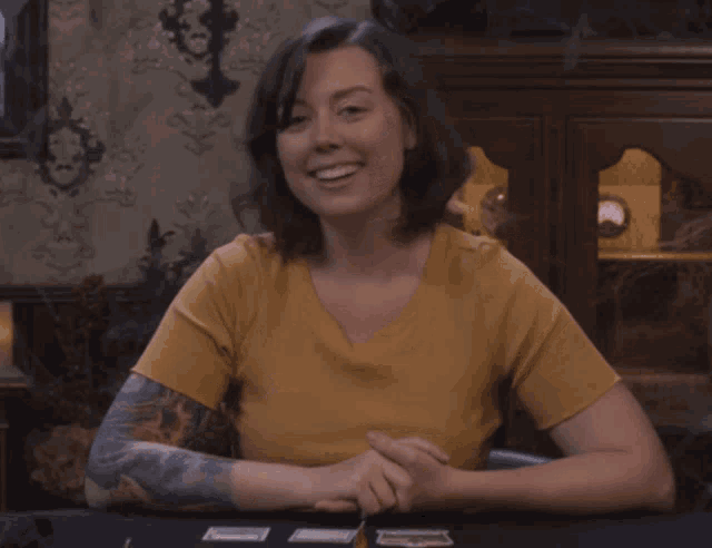 a woman with a tattoo on her arm is playing cards