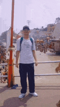 a man wearing a lacoste shirt is standing on a bridge