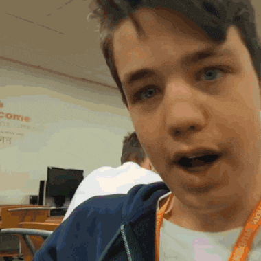 a young man with a lanyard around his neck that says welcome