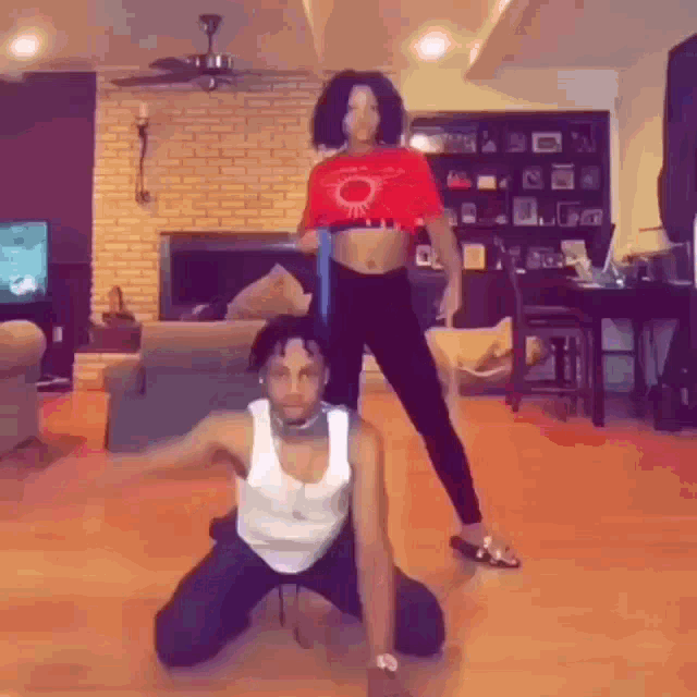 a man and woman are kneeling down in a living room .