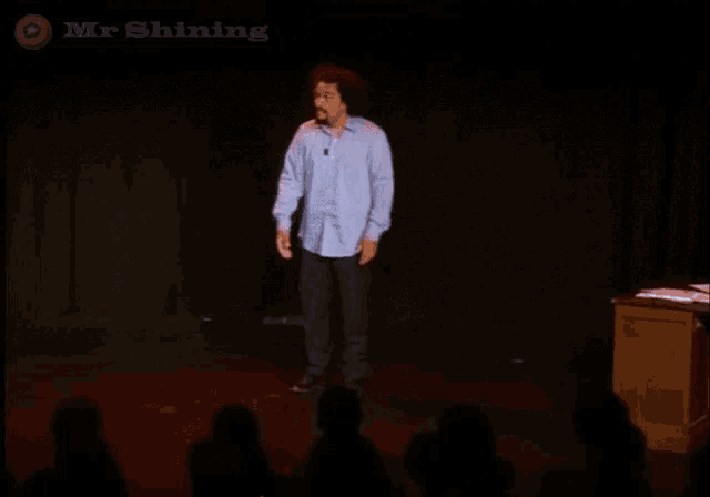 a man stands on a stage with the words tu vas la prendre celle-la on the bottom