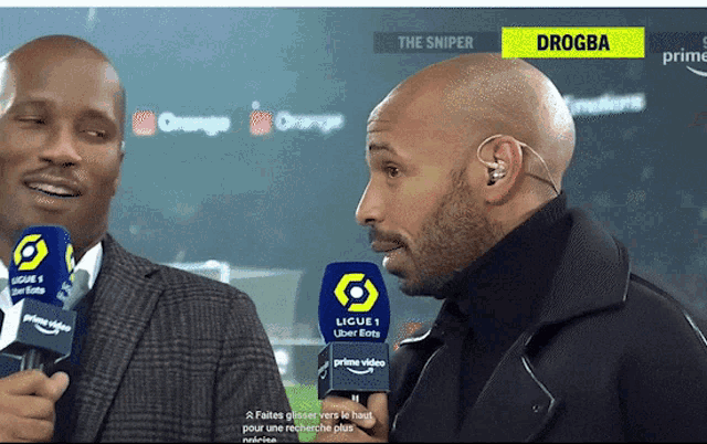 two men are talking to each other and one of them is named drogba