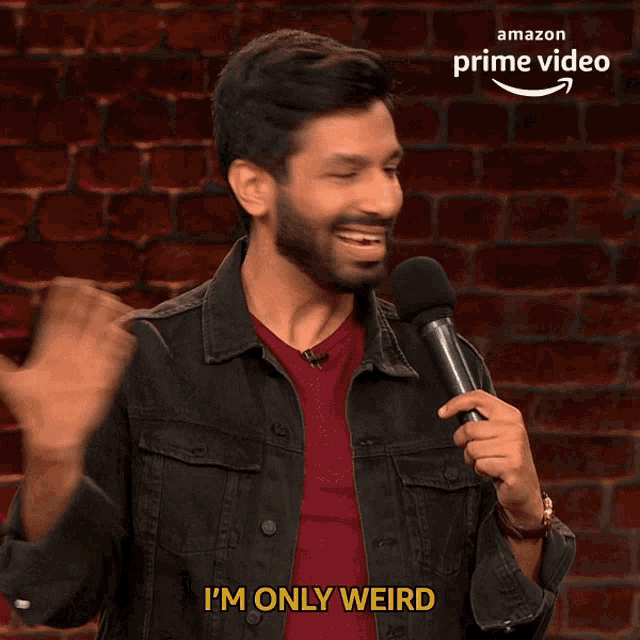 a man is holding a microphone and says i 'm only weird