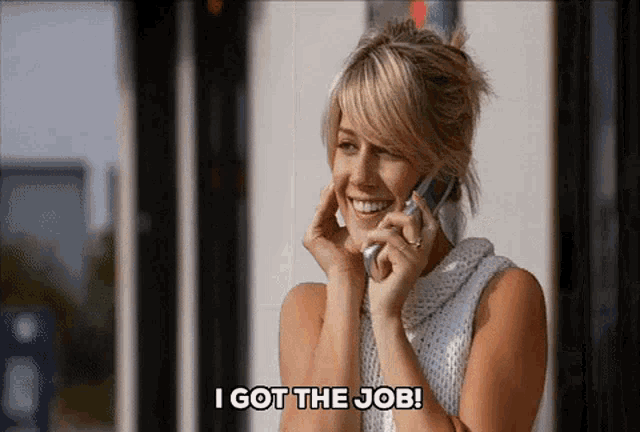 a woman talking on a cell phone with the words i got the job written below her