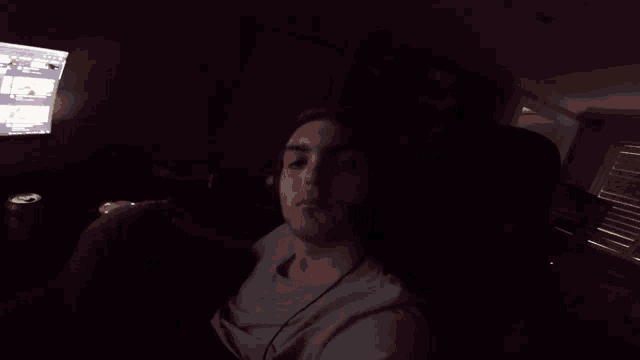 a man wearing headphones sits in front of a computer screen