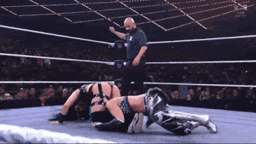 a man in a wrestling ring with a w logo on his shirt