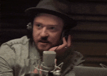 a man wearing headphones talks into a microphone