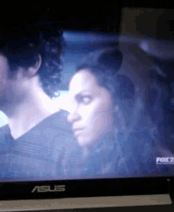 an asus computer monitor shows a man and a woman