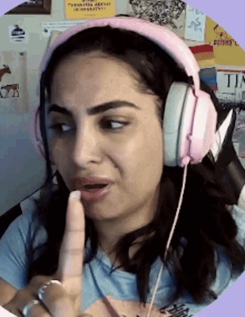 a woman wearing pink headphones is making a silly face