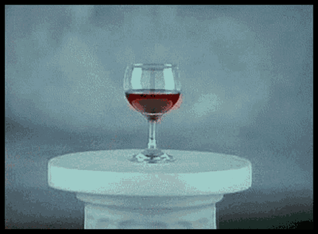 a glass of red wine is on a table