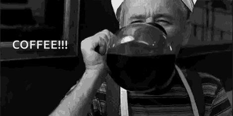 a man is drinking a large cup of coffee from a glass .