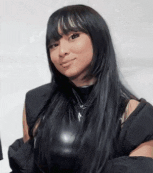a woman with long black hair and bangs is wearing a black leather top and a black jacket .