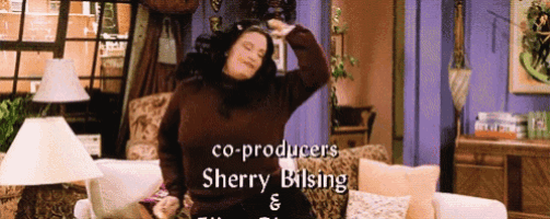 a woman in a brown sweater is dancing in a living room with the name sherry bilsing on the bottom