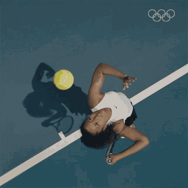 a woman is playing tennis on a blue court