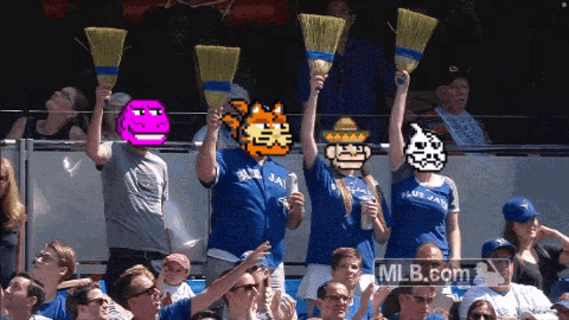 a group of blue jays fans holding up brooms in the stands