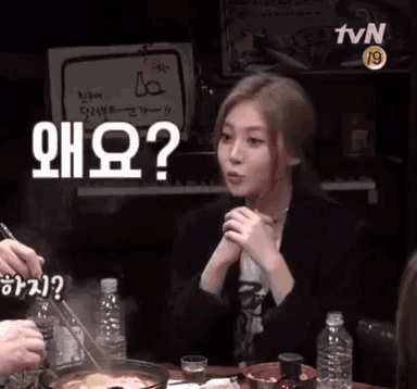 a woman sitting at a table with a sign that says tvn 19 on it