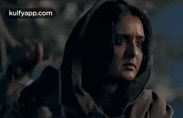 a woman is holding a lantern in her hand and crying .